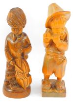 Two carved treen figures, depicting a child playing a cello, 33cm high, and a child playing a piccol