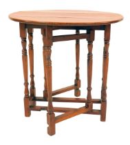 A 20thC oak small gate leg table, circular top on turned tapering legs united by stretchers, 65cm hi