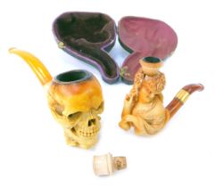 A meerschaum pipe, modelled as a hand holding skull, with simulated amber cheroot, 15cm long, togeth