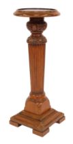 An early 20thC mahogany jardiniere stand, the circular moulded top above a leaf carved cylindrical r