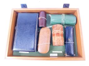 A group of leather travel sewing cases, comprising a brown leather case of cylindrical form containi