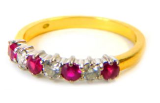 An 18ct gold, ruby and diamond half hoop dress ring, set with four round brilliant cut rubies and th