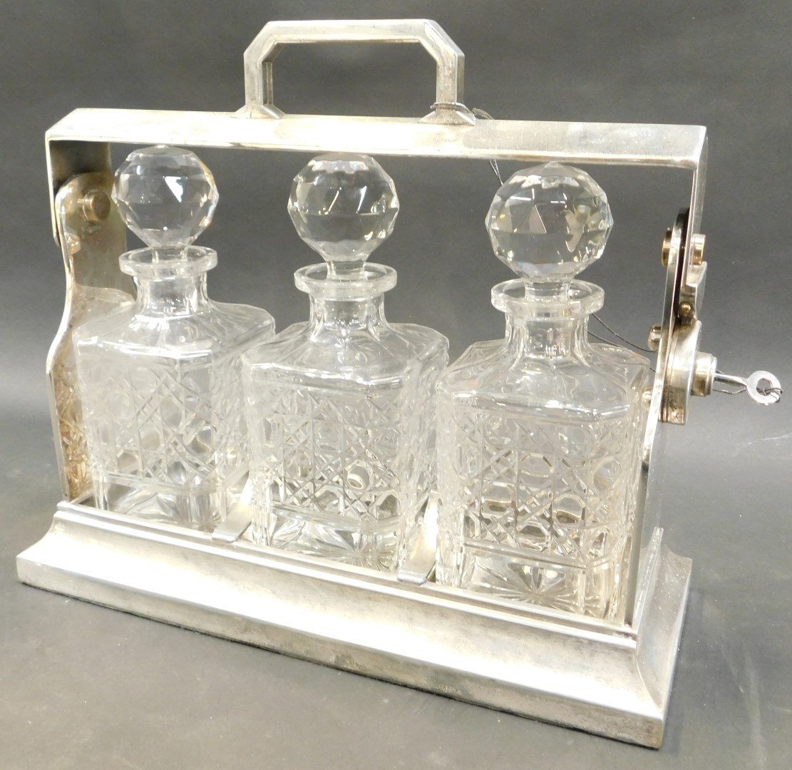 A 20thC silver plated Tantalus, with three cut glass decanters and stoppers, the stand is stamped - Image 2 of 2