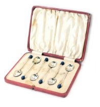 A set of six George V silver bead topped and enamel spoons, each set with a blue bead top and Royal
