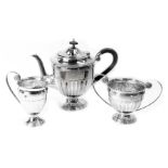 A George V silver tea service, comprising teapot, milk jug and sugar bowl, each of Neoclassical desi