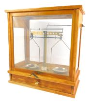 A cased set of vintage balance scales, in a pine case with drawer, containing weights, 47cm high, 44