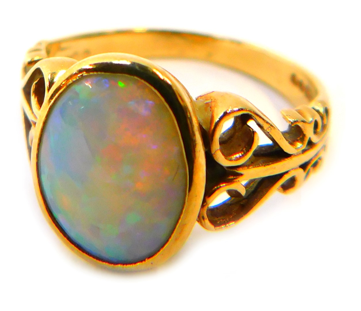 A 9ct gold opal dress ring, the oval opal in a rub over setting, with scroll design shoulders, ring