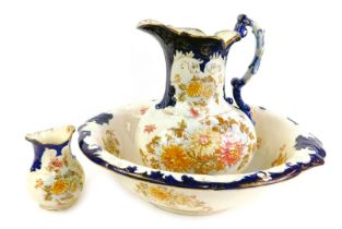 A late 19thC pottery wash jug and bowl set, toothbrush holder, each decorated with flowers picked ou