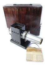 An early 20thC projector, with reel, in stained pine case, the projector 20cm high.