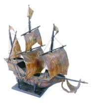 A wooden model of a galleon, with painted pigskin sails, and painted base, on stained stand, 58cm hi