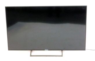 A Sony 55" television, model number 55XE7093, with remote and lead.