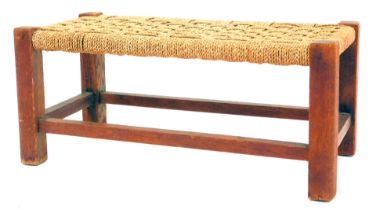 An early 20thC oak framed stool, the rectangular top with lattice braided seagrass top, on stiles u