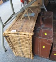 An empty Brexton wicker hamper basket, and a tan leatherette trunk.