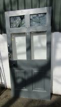 A wooden front door, painted in grey, with four glass sections to top and moulded base, 197cm high,