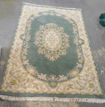 An Indian wool cut rug, on a green floral ground.