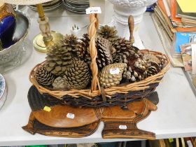 Two carved tribal panels, wicker basket and quantity of pine cones.