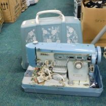 A cased Jones sewing machine, in light blue, with carry case.
