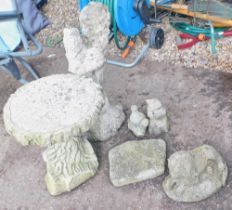 A group of reconstituted stone garden wares, comprising millennium plaque, child with fish, recumben