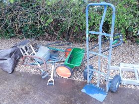 A metal and wooden topped stool, galvanised shovel, sack barrow, seed spreader, gardening tools, etc