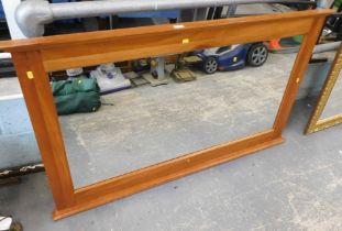 A pine finish rectangular over mantel mirror, 82cm x 139cm.