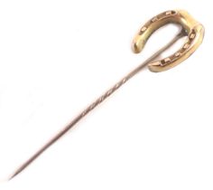 A horse shoe stick pin, the horse shoe on steel pin, yellow metal stamped 9ct, and a small yellow me