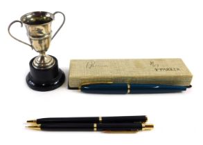 A cased Parker biro, a two pen case set, and a small George V silver trophy cup, 0.51oz, on socle. (