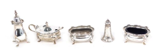 An Edward VII silver three piece cruet set, comprising two salts, a mustard and spoon, one with blue