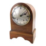 A 19thC mahogany and boxwood strung mantel clock, with a silvered dial, and an arched case, 30cm hig