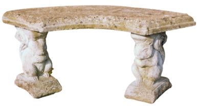 A reconstituted stone garden bench, with two squirrel supports and a curved seat, 45cm high, 94cm di