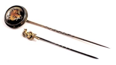 Two stick pins, comprising a 19thC Wessex pin, with a painted fox pin head, in a rope twist bordered