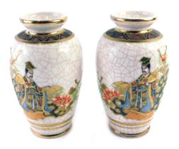 A pair of Japanese Earthenware vases, each decorated with figures in elaborate costume, picked out i