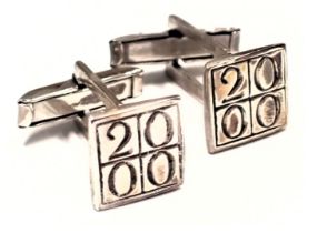 A pair of silver millennium cufflinks, each with a square cuff link head, marked 2000, 9.1g all in,