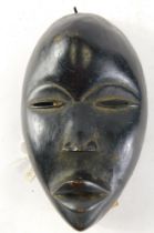 A Dan spiritual passport peace mask with downcast eyes, Cote D'Ivoire, 22cm high.