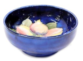 A Moorcroft sweet pea pin dish, on a dark blue ground with pale pink flower, stamp to underside, 8cm