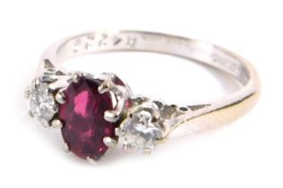 An 18ct white gold ruby and diamond three stone dress ring, the oval cut ruby in claw setting, 6.2mm