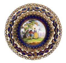 A Dresden porcelain plate, painted with figures, in 18thC scene within cobalt blue in gilt pierced b