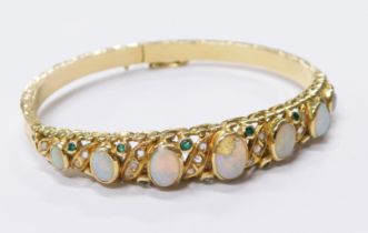 A Victorian opal hinged bangle, the design set with seven graduated oval opals and tiny diamond twis