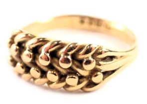 An 18ct gold dress ring, of three layer knot and weave design, with pierced V splayed shoulders, rin