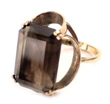 A 9ct gold smoky quartz dress ring, the rectangular cut smoky quartz in four double claw setting, in