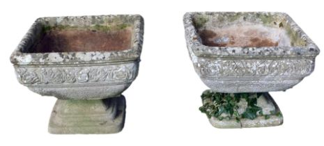 Two reconstituted stone square urn planters, each with a rose border, on a three layered stepped foo