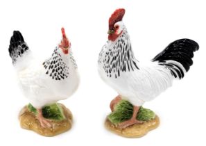 Two modern John Beswick hens, with polychrome painting, on a white ground, 14.5cm high. (2)