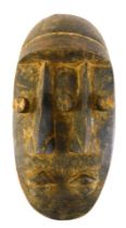 A Grebo (Krou) three eyed janus face mask, Liberia, 34cm high.