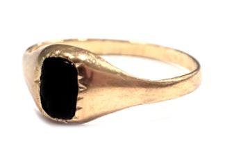 A 9ct gold signet ring, the rectangular black onyx panel in a rub over setting, on yellow metal band