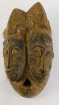 A Baule Old 'Janus' two faced portrait mask (Mblo), Cote D'Ivoire, 36cm high.