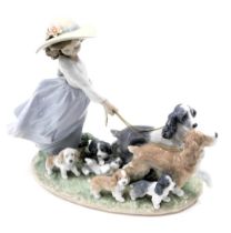 A Lladro privilege figure group, number RR53H, depicting girl walking dogs and puppies, on oval base