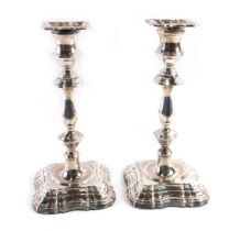 A pair of Queen Elizabeth II silver candlesticks, of fluted form, on a stepped base loaded with gree