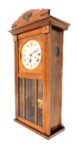 A 1950s/60s oak cased wall clock, with the arch pediment top above silvered Roman numeric dial, with