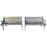 A pair of mid 20thC slatted wooden garden benches, with cream painted ends with urn and lion mask, 7
