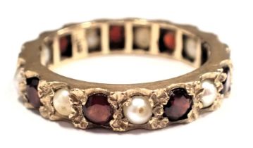 A garnet and seed pearl eternity ring, of hammered claw design, yellow metal unmarked, ring size N½,