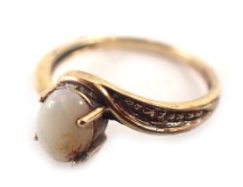 A 9ct gold dress ring, the oval opal in four claw setting, with twist design shoulders, bead effect,